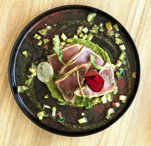 Thon mi-cuit et condiments sur assiette noire